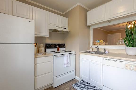A kitchen with white appliances and cabinets.