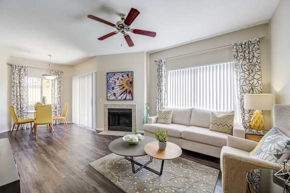 A living room with a fireplace, a couch, and a dining table.