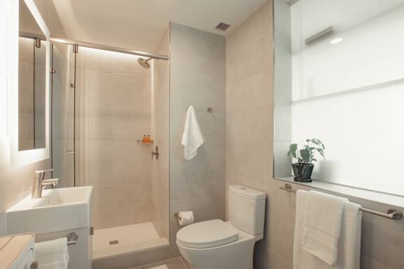 a bathroom with a shower and a toilet and a sink at Scout Living, powered by Placemakr Apartments, Atlanta, GA, 30308