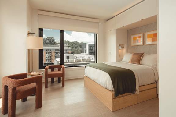 a hotel room with a bed and a window at Scout Living, powered by Placemakr Apartments, Atlanta, GA
