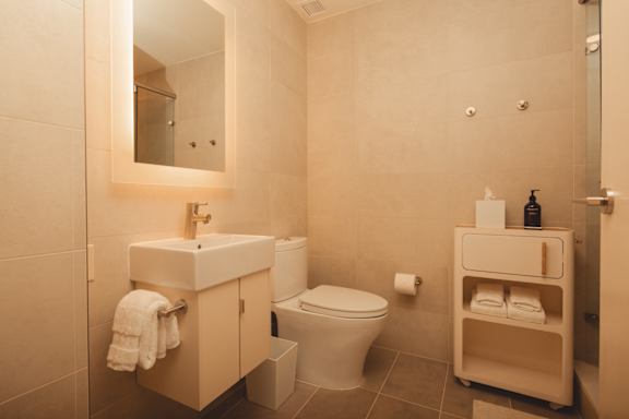 a bathroom with a toilet and a sink and a mirror at Scout Living, powered by Placemakr Apartments, Georgia 30308