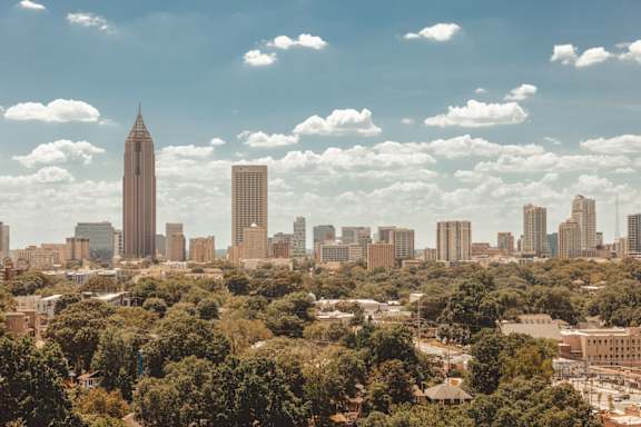 the skyline of the city with a blue cloudy sky and trees at Scout Living, powered by Placemakr Apartments, Atlanta, 30308