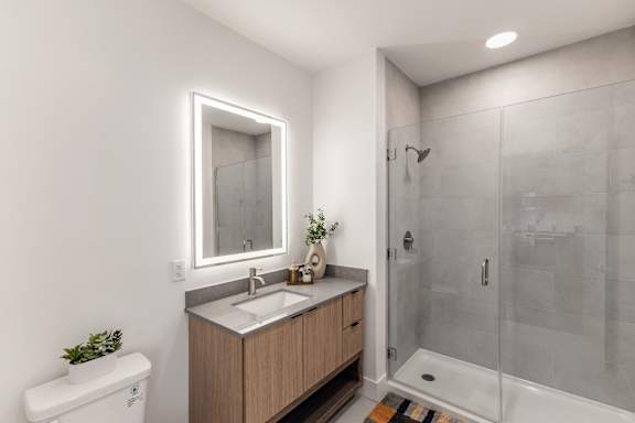 Bathroom with a wooden vanity and a glass shower at Anthem House Apartments, Huntsville, Alabama