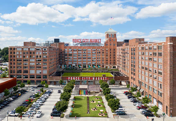 an aerial view of a large brick building with a large sign on top of it at Scout Living, powered by Placemakr Apartments, Georgia