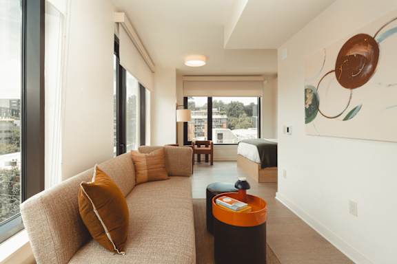 the living room of a hotel suite with a couch and a table at Scout Living, powered by Placemakr Apartments, Atlanta, 30308
