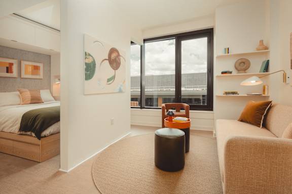 a living room with a large window and a couch and a chair at Scout Living, powered by Placemakr Apartments, Atlanta, GA