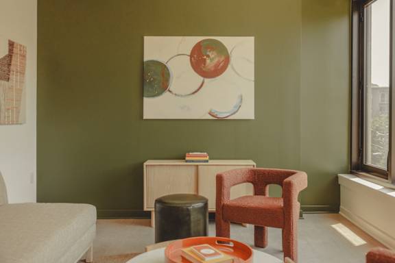 a living room with a chair and a painting on the wall at Scout Living, powered by Placemakr Apartments, Georgia