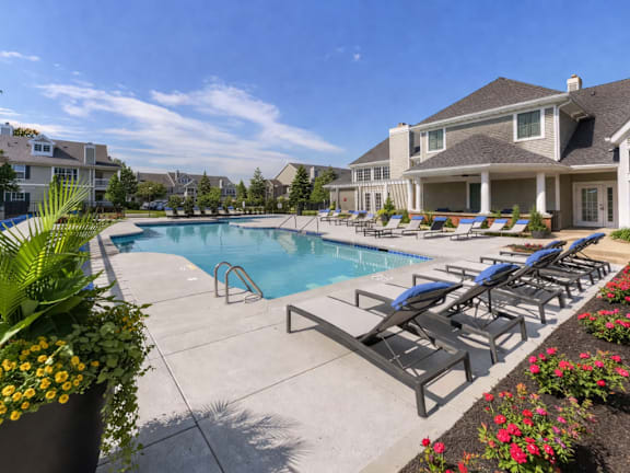 A pool surrounded by lounge chairs and flowers.