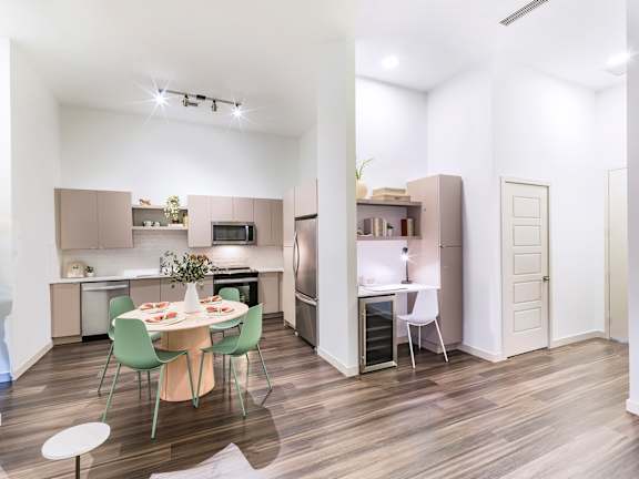 A modern kitchen with a dining table set for two.