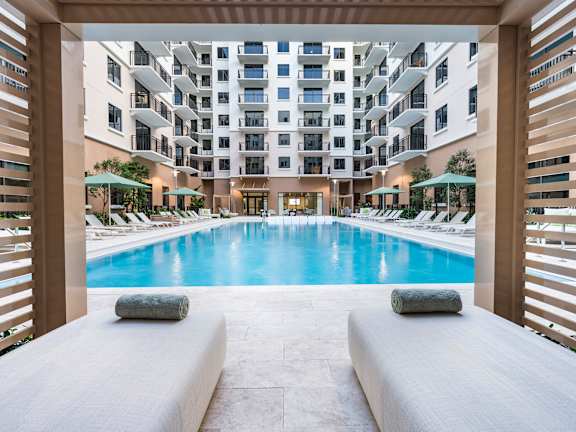 A large indoor swimming pool with a view of a multi-story building.