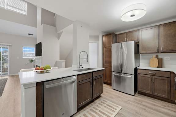 A modern kitchen with a white countertop and a refrigerator.