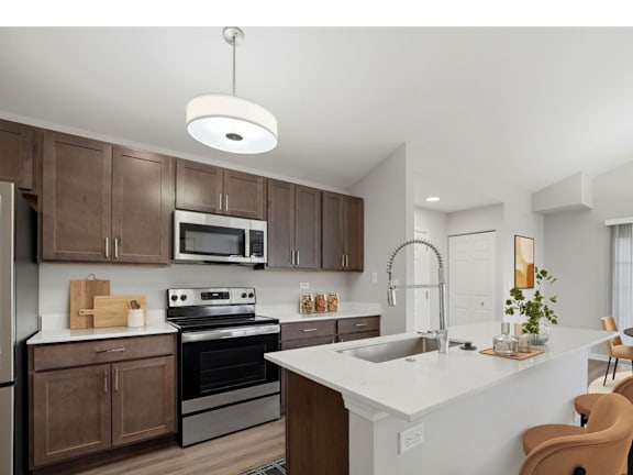 A modern kitchen with brown cabinets and white countertops.