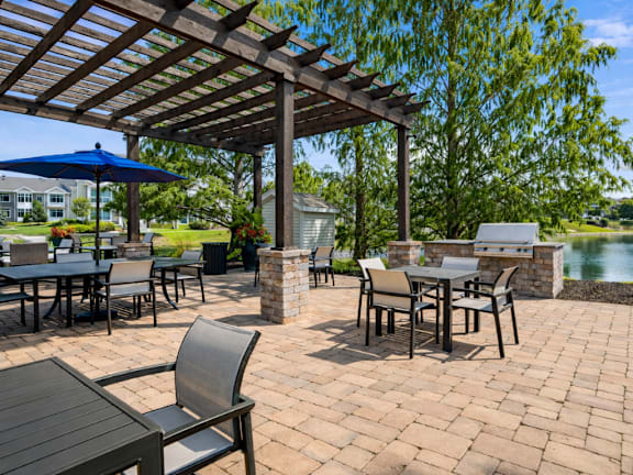 A patio with a table and chairs under a pergola.