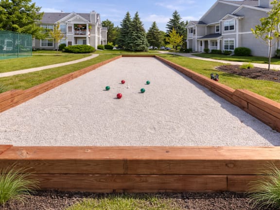 A sand volleyball court with green, red and white balls.