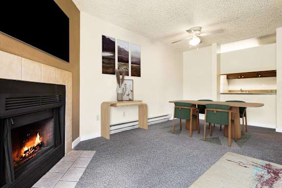 a living room with a fireplace and a table and chairs at Eagles Landing Apartments, Everett, WA