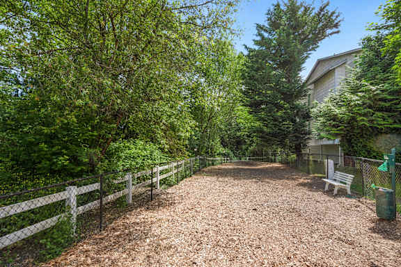 the path to the yard with a bench and a fence