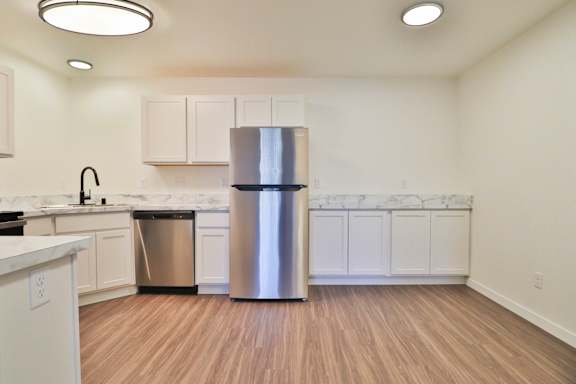 A kitchen with a stainless steel refrigerator and a white countertop.