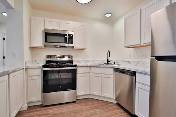 A kitchen with white cabinets and stainless steel appliances.