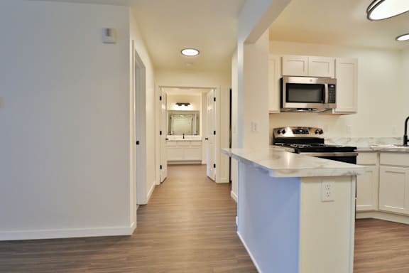 A kitchen with a white counter top and a blue stripe.
