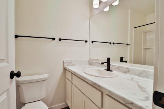 A white toilet sits next to a sink in a bathroom.