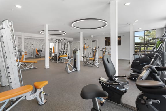 a gym with various exercise equipment and weights on the floor