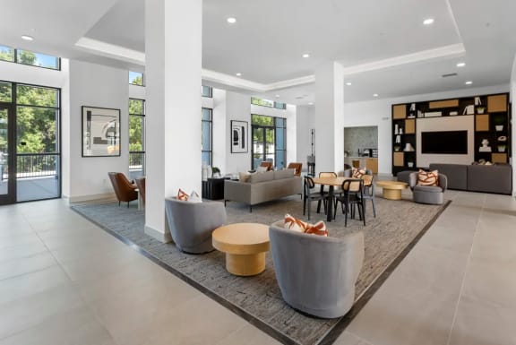 a living room with couches and chairs and a television at The Venue at Orange Apartments, Redlands, CA