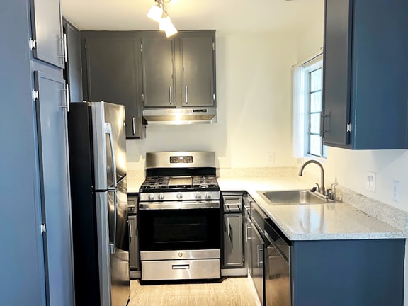 a kitchen with a stove refrigerator and sink