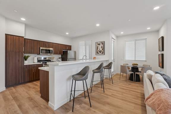 Spacious modern kitchen in The Park apartment home with breakfast bar, quartz countertops, and stainless steel appliances