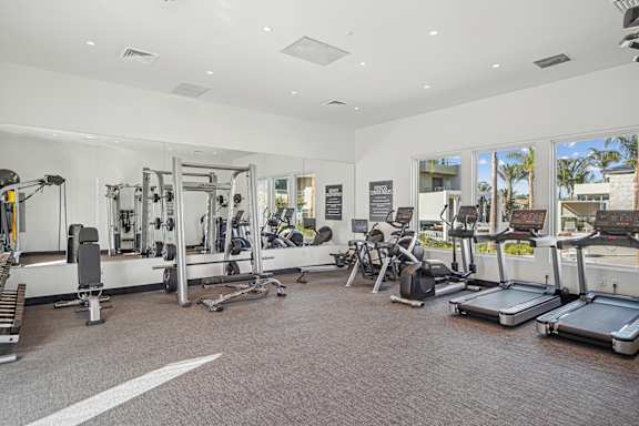 A spacious gym with a variety of equipment including treadmills, weights, and exercise machines.