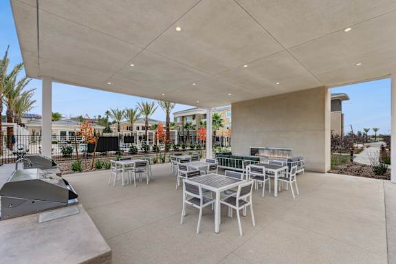 Poolside barbecue grilling station with dining tables, and a fireside lounge.