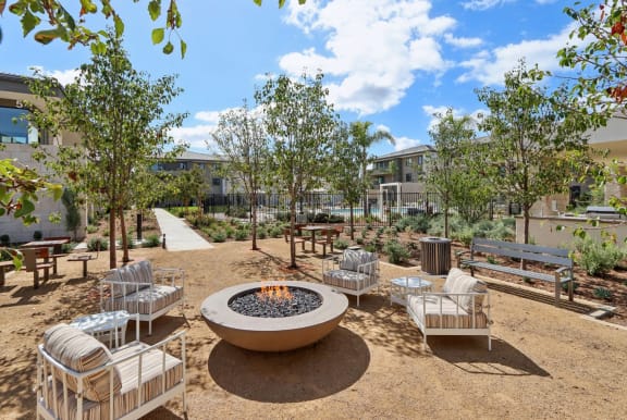 an outdoor patio with a fire pit and benches at The Max on Jefferson Apartments, Murrieta