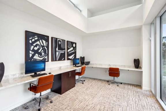 a large office space with desks and chairs and monitors at The Max on Jefferson Apartments, California, 92562