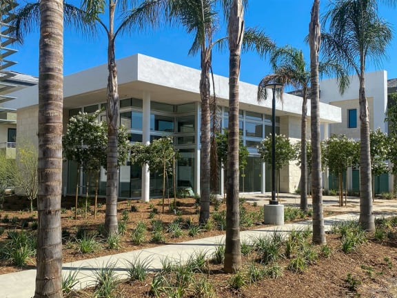 a building with palm trees in front of it at The Max on Jefferson Apartments, California
