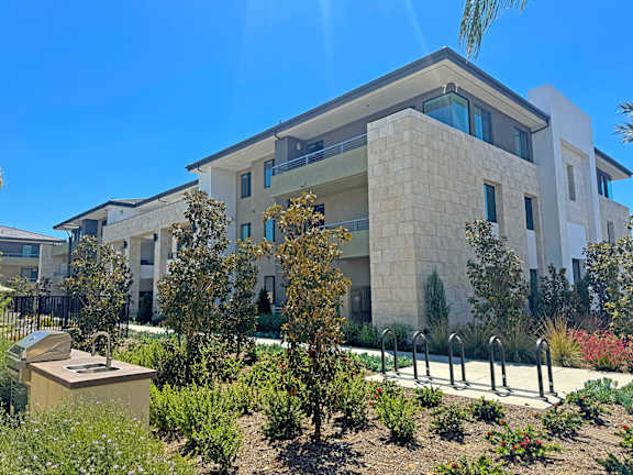building exterior surrounded by gorgeous landscaping and poolside views at The Max