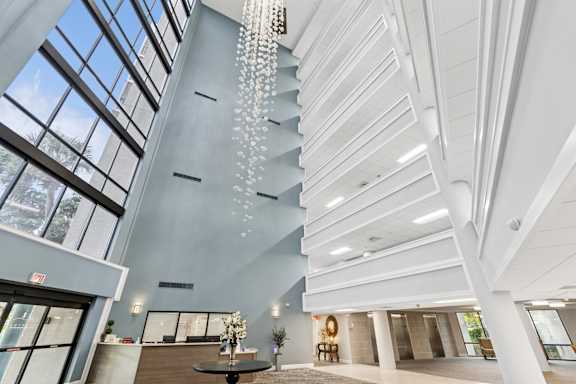 A modern interior with a chandelier and a view of the sky through the windows at Hampton Apartments, Clearwater, FL, 33759