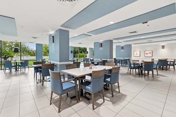 A large dining room with tables and chairs at Hampton Apartments, Clearwater 33759