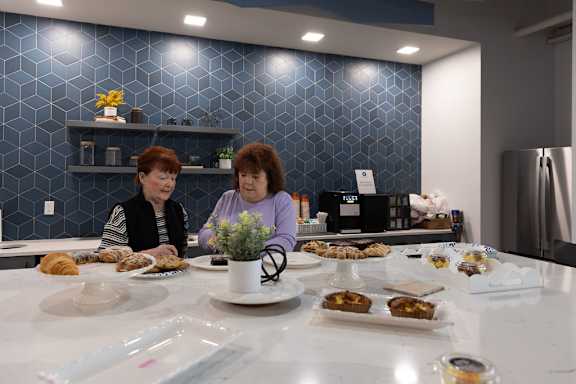 two women sitting at a table with food at The Residences at Tesson Ridge, Missouri
