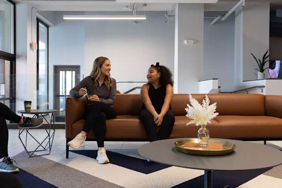 two women sitting on a couch talking in a lobby at The Residences at Tesson Ridge, Saint Louis, MO, 63128