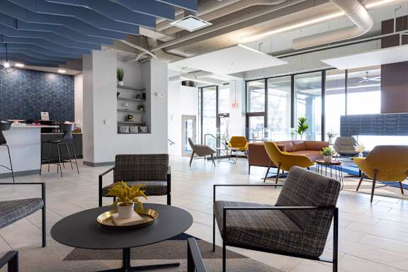 a lobby with tables and chairs and a large window at The Residences at Tesson Ridge, Saint Louis, MO, 63128