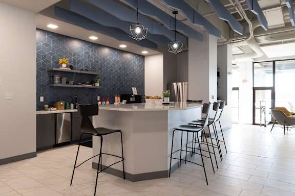 a kitchen with a counter and chairs in a lobby at The Residences at Tesson Ridge, Missouri