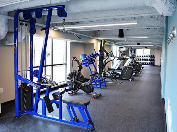 A gym with a blue weight bench and other equipment.