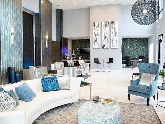 A living room with a white couch and a blue chair.