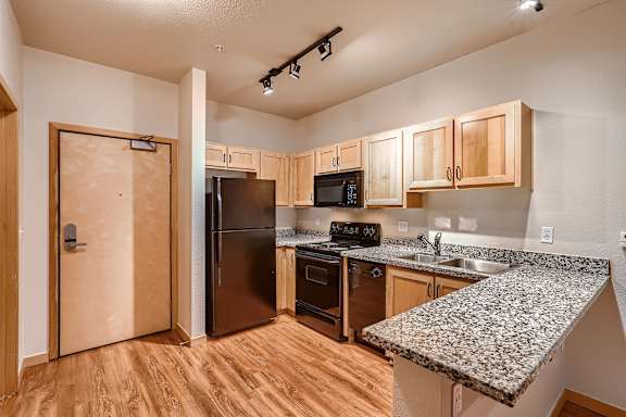 A kitchen with wooden cabinets and a granite countertop.