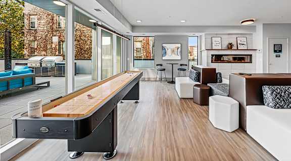 Community game room with shuffleboard and modern seating at Pure Lowry Apartments, Minneapolis, MN 55405