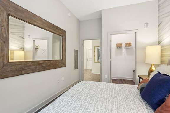 a bedroom with a bed and a mirror on the wall