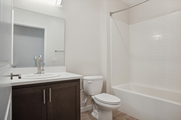 A white bathroom with a toilet, sink, and bathtub.