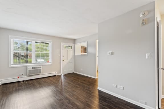 A room with a window and wooden floors.