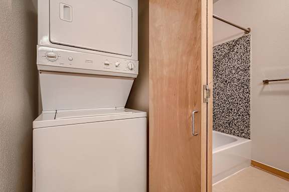 A white dryer and washer are stacked on top of each other.