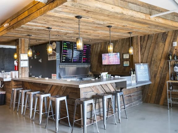 Taproom bar with wood paneling and pendant lighting at Brooklyn Yard Apartments, Portland, Oregon