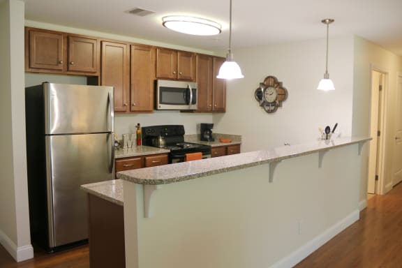 a kitchen with a long counter and a stainless steel refrigerator at Mallory Ridge, Bloomfield, 06002